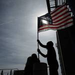 In this April 24, 2017, file photo, supporters raise a flag outside of the federal courthouse in Las Vegas. Federal prosecutors will try again to convince a jury that four men conspired with Nevada rancher Cliven Bundy and his family when they took up arms during a 2014 standoff that stopped federal agents from confiscating cows belonging to the states&rsquo; rights advocate. July selection begins Monday, July 10. (AP Photo/John Locher, File)