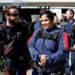 Yessica Ramos (right) is led by her instructor out to a waiting plane before skydiving at Skydive Snohomish&rsquo;s Fill the Sky with Hope event on Saturday, July 1. (Ian Terry / The Herald)