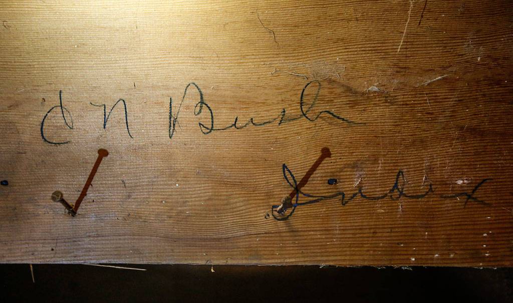 Blair Corson found the signature of Clarence Bush, the original owner of Bush House, when he removed a covering on the lower underside of a hotel staircase. (Dan Bates / The Herald)