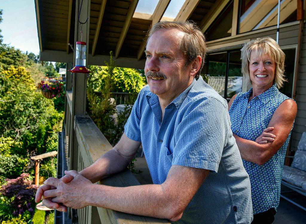 Janice Tallman and her husband, Steve, enjoy a view overlooking the unique and beautiful garden that winds around their home. (Dan Bates / The Herald)