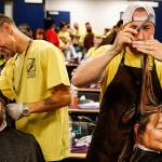 Alex Frazier (left) cuts the hair of Cody Phillips while David Hutton does Lohti Hevly&rsquo;s hair during last year&rsquo;s Project Homeless Connect. The two were volunteering from Paroba College of Cosmetology in Everett. This year&rsquo;s event is scheduled for 9 a.m.-2 p.m. July 20 at Evergreen Middle School in Everett. (Dan Bates/The Herald)