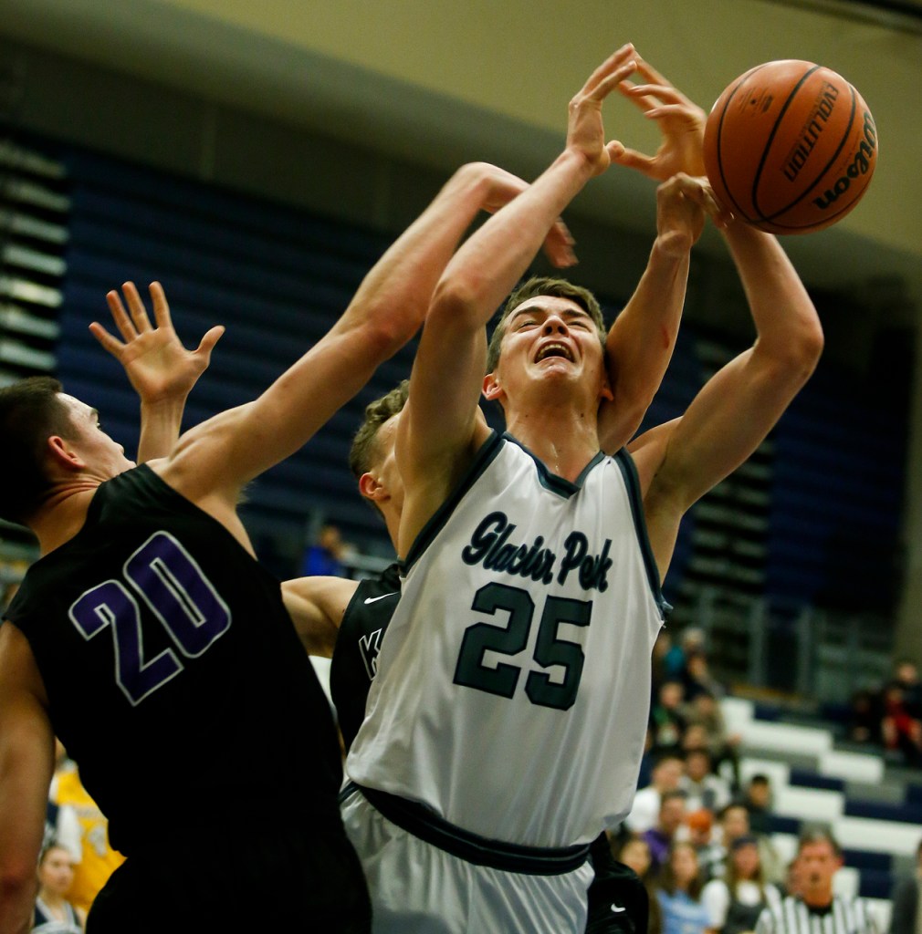 Glacier Peak&rsquo;s Noah Forman (25) is fouled by Kamiak&rsquo;s Patrick Olson (20) and Daniel Sharpe during a game Tuesday at Glacier Peak High School in Snohomish. Glacier Peak went on to defeat Kamiak 62-48. (Ian Terry / The Herald)