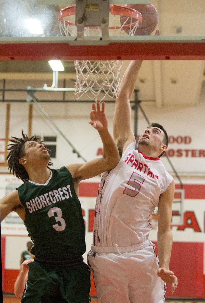 Stanwood&rsquo;s Chase Strieby (right) tips the ball in for a basket with Shorecrest&rsquo;s Malcolm Rosier-Butler defending during a game Tuesday, Feb. 7, in Stanwood. The Spartans won 75-61 to capture the Wesco 3A regular-season title. (Andy Bronson / The Herald)