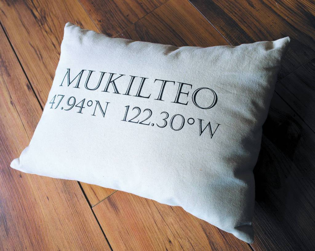 A Mukilteo pillow shows latitude and longitude of the city at Beach Glass in Mukilteo. (Andy Bronson / The Herald)