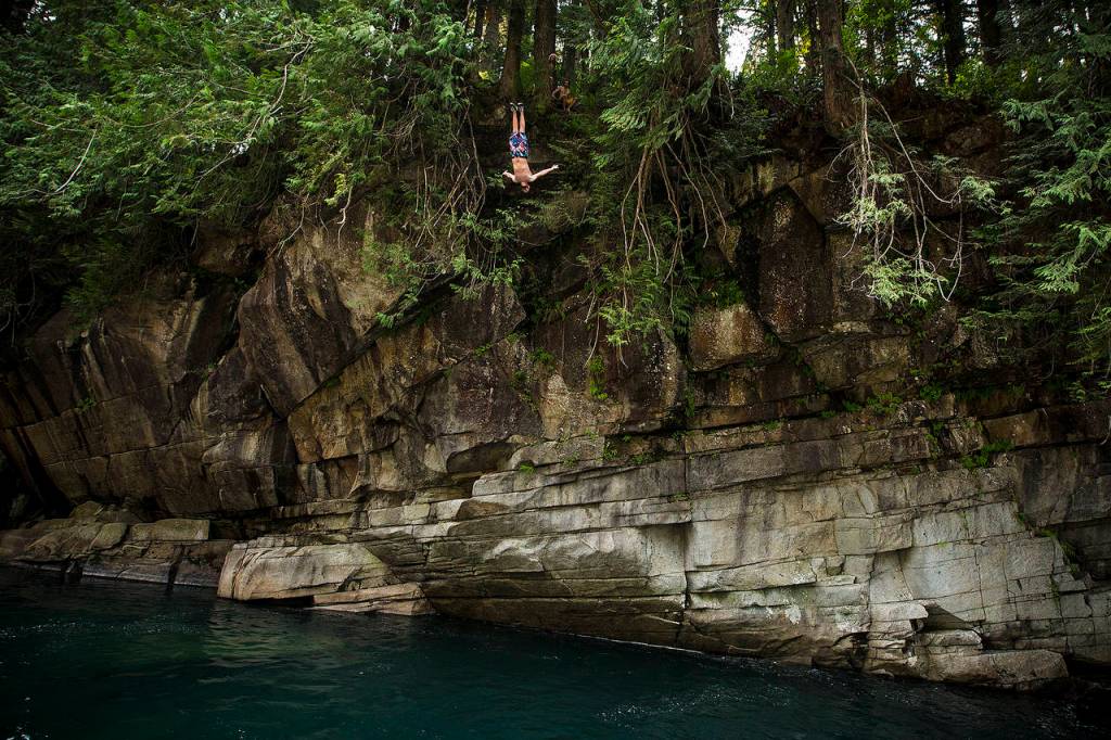 Wade Anderson, of Edmonds, backflips from a 55-foot perch at Eagle Falls near Index on Saturday, Aug. 5. (Ian Terry / The Herald)