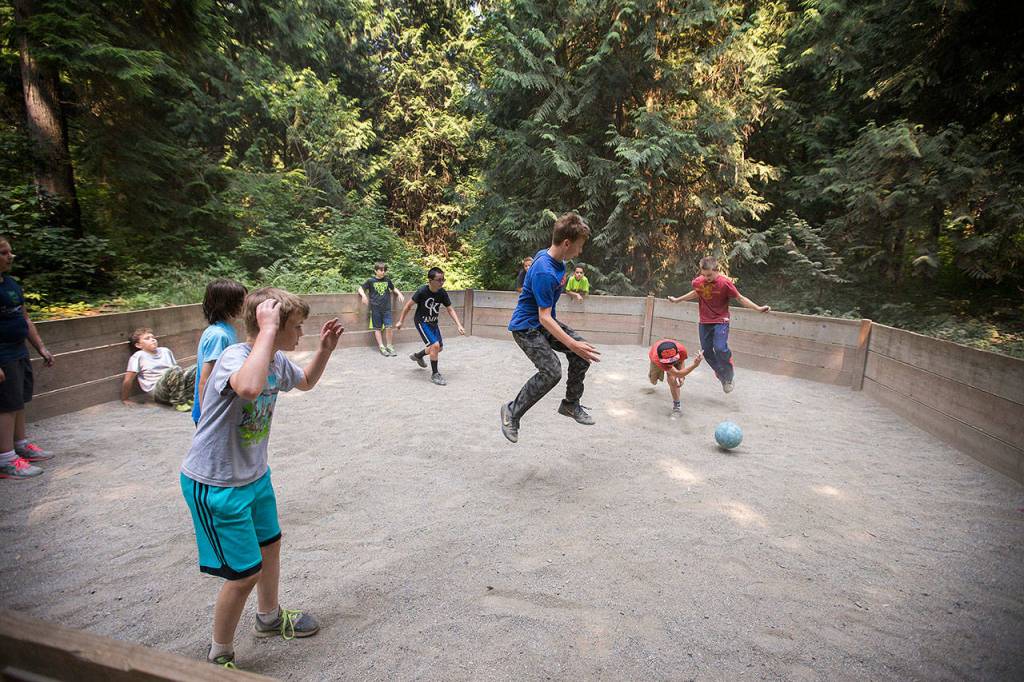 Campers leap to avoid being hit by the ball as they play Gaga, a version of dodgeball, at Camp Killoqua on Aug. 2 in Stanwood. Campers rotate through various activities such as human foosball, low and high ropes, archery and more during the week-long camp. (Andy Bronson / The Herald)