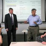 University of Washington Bothell&rsquo;s forensic accounting class students Yiya You (left) and Rochelle McElroy (right) talk with professor Rajib Doogar (center right) and class mentor Kenneth Hines, a former IRS investigator. (Ian Terry / The Herald)