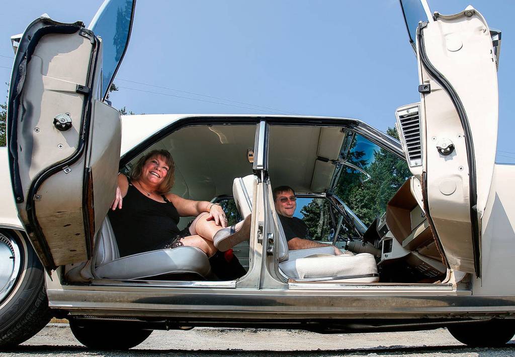 Vicki and Ron Selia look out through the Continental&rsquo;s open doors, commonly referrred to as &ldquo;suicide doors&rdquo; on those models. (Dan Bates / The Herald)