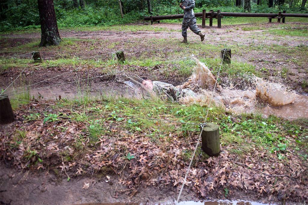 Sgt. Grant Reimers, a heavy vehicle driver with 1859th Light-Medium Transportation Company, Nevada National Guard, dives into the low-crawl obstacle on the confidence course during the 2017 Army National Guard Best Warrior Competition on July 18 at Camp Ripley, Minnesota. This was the fifth event of the day the competitors completed on the second day of the competition. (Minnesota National Guard / Sgt. Sebastian Nemec)