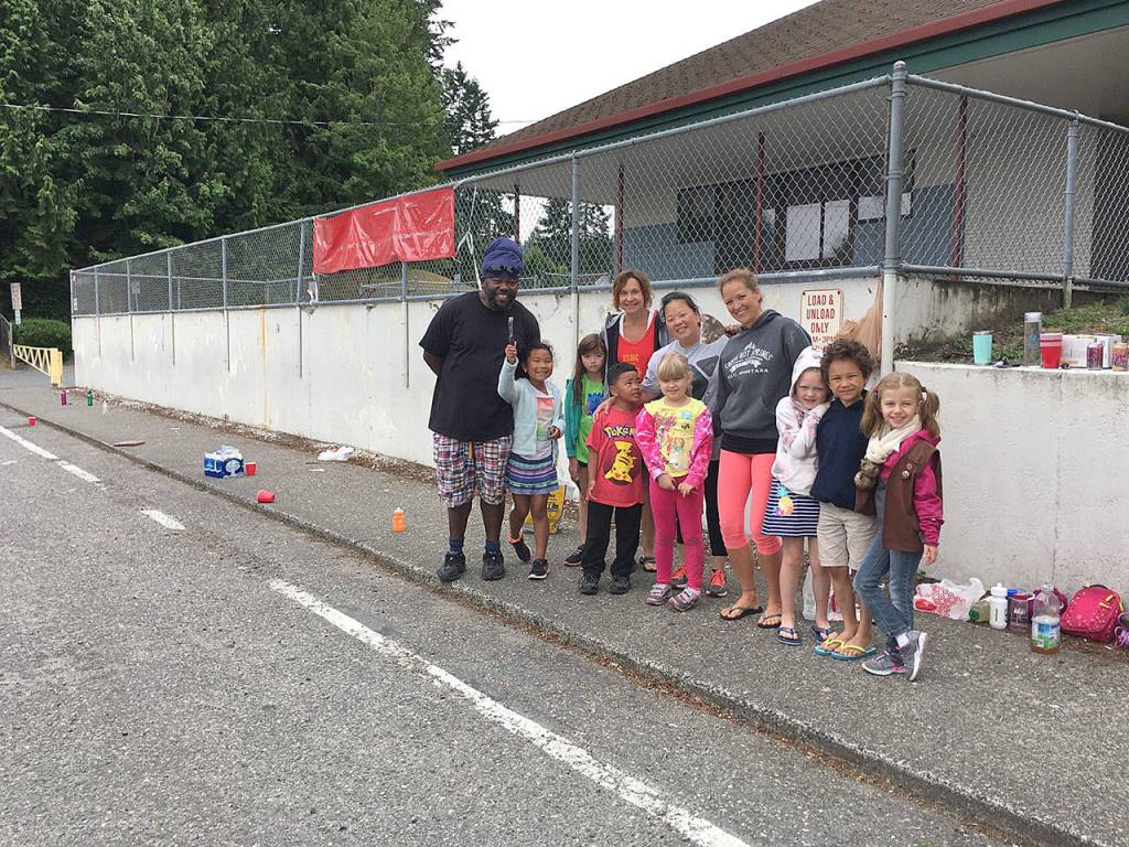 Artist and parent Nico Gomez is shown with some of the Girl Scouts who cleaned and scraped the wall so he could paint the mural at Lowell Elementary School in Everett. (Submitted photo)