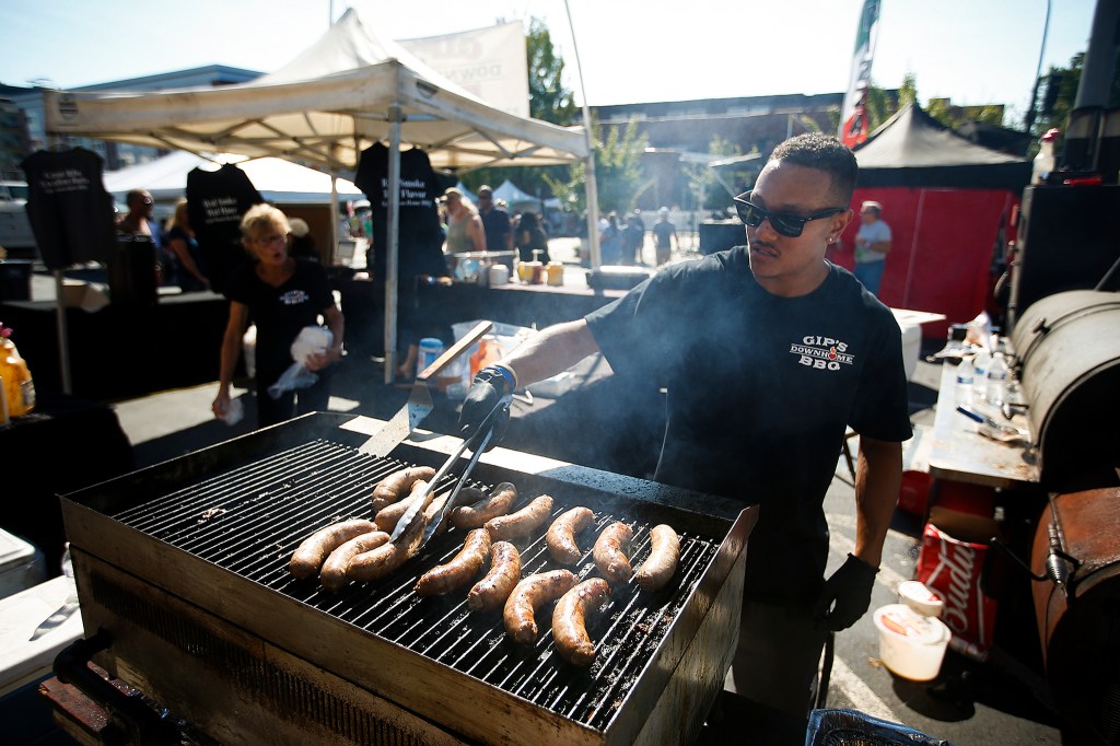 Jarred Smith gets a batch of brats ready while working at Gip&rsquo;s Downhome BBQ during last year&rsquo;s Everett Craft Beer Festival. Gip&rsquo;s Downhome BBQ will be one of many food vendors showcased at this weekend&rsquo;s Everett Food Truck Festival. (Ian Terry / The Herald)