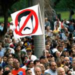 An anti-government demonstrator waves a flag against Venezuela President Nicolas Maduro during a vigil in honor of those who have been killed during clashes between security forces and demonstrators in Caracas, Venezuela, on Monday. During four months of street protests, at least 125 people have died. (AP Photo/Ariana Cubillos)