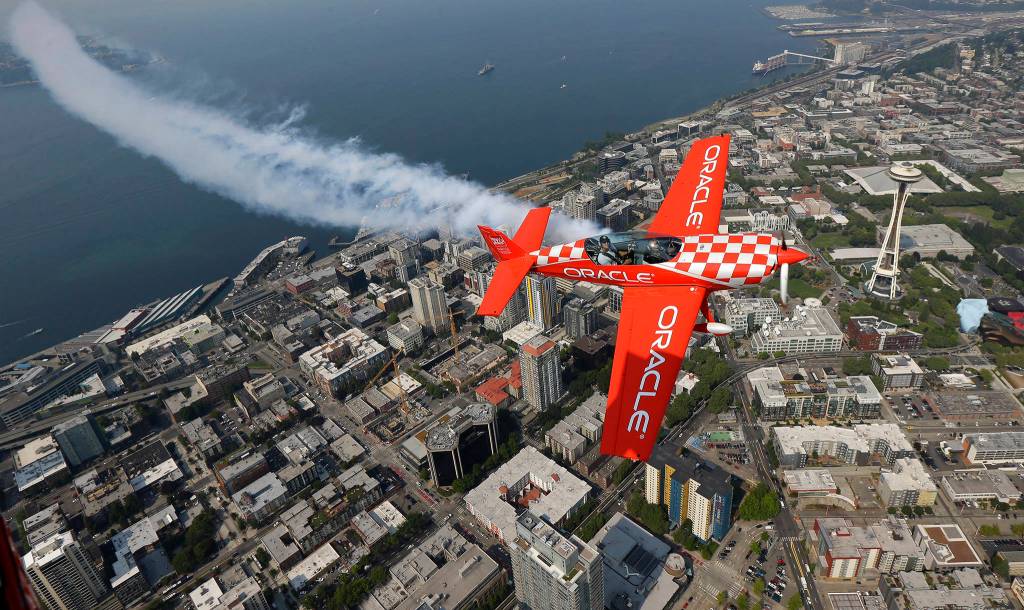 Team Oracle stunt pilot Sean D. Tucker flies his Extra 300L plane above the Space Needle on Aug. 2 in Seattle. In the rear seat is Seattle Seahawks tight end Jimmy Graham, who is also a stunt pilot and was invited along by Tucker as Tucker prepared for his performances at the Seafair Air Show. (AP Photo/Ted S. Warren)