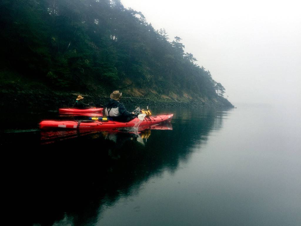 Kayakers paddle through the San Juan Islands fog. (Aaron Swaney / For The Herald)