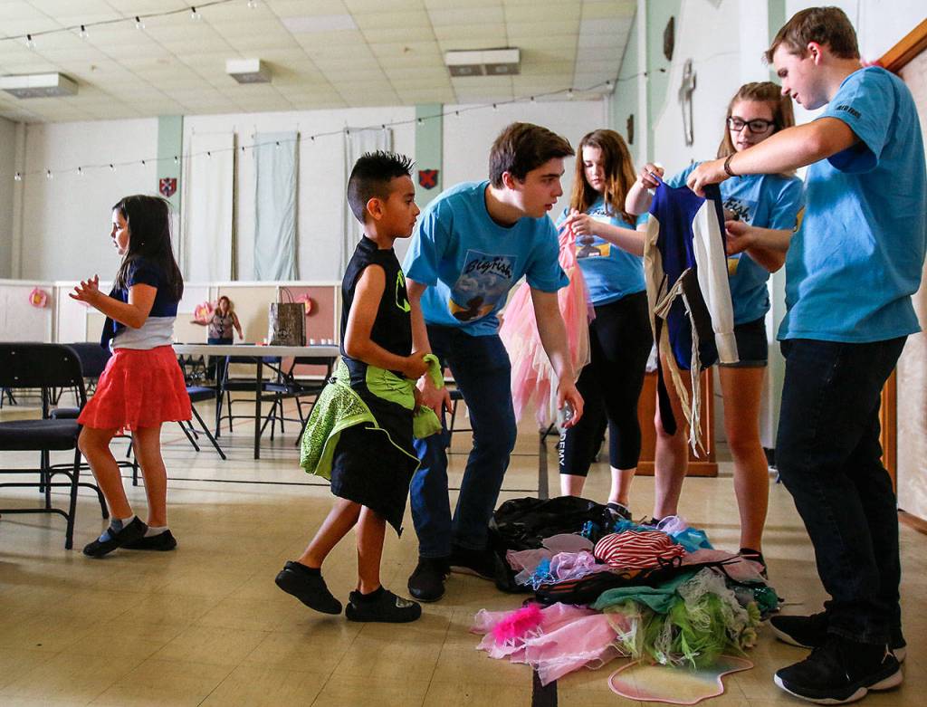 Archbishop Murphy High School students in matching blue t-shirts from left, Jeff Wilson, Eleanor Lund, Catherine Pepper and Bryce Carabello bring out costumes to entice youngsters with their 2017 "Intro to Theater Workshop," August 9 at Trinioty episcopal Church. (Dan Bates / The Herald)