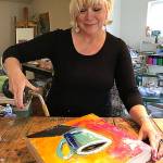 Machias artist Jackie Cort demonstrates her encaustic work with colored bees wax. Cort is the poster artist for this year&rsquo;s Schack Art Center Fresh Paint Festival of Artists at Work. She also will be demonstrating her work Aug. 19 and 20 at the festival in Everett. (Gale Fiege / The Herald)