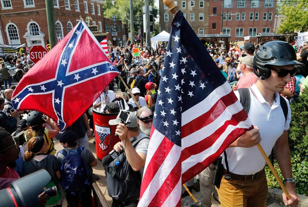 White nationalist demonstrators walk into Lee park surrounded by counter demonstrators in Charlottesville, Virginia, on Saturday. (AP Photo/Steve Helber)