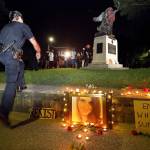 Police move in at Piedmont Park in Atlanta late Sunday to prevent protesters from toppling a Confederate monument with a chain after they spray-painted it. The peace monument at the 14th Street entrance depicts a angel of peace stilling the hand of a Confederate soldier about to fire his rifle. (Curtis Compton/Atlanta Journal-Constitution via AP)