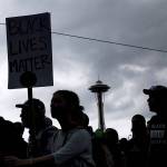 People attend a rally Sunday in Seattle. Hundreds of demonstrators and counter-protesters converged downtown one day after violent clashes in Charlottesville, Virginia. (Grant Hindsley/seattlepi.com via AP)