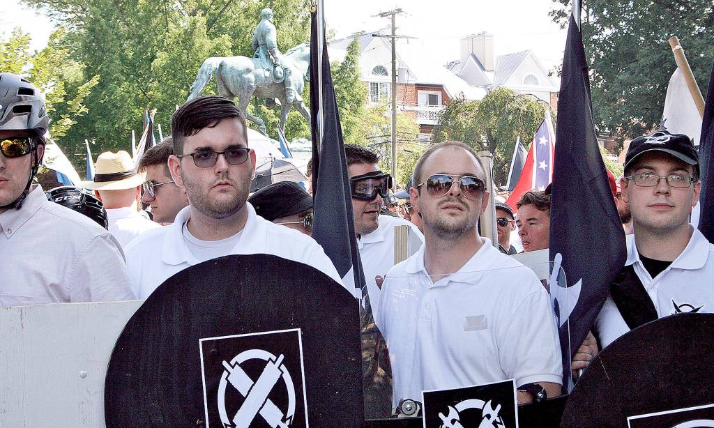 James Alex Fields Jr. (second from left) holds a black shield on Saturday in Charlottesville, Virginia, at the white supremacist rally. Fields was later charged with second-degree murder and other counts after authorities say he plowed a car into a crowd of people protesting the rally. (Alan Goffinski via AP)
