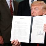 President Donald Trump holds a signed memorandum calling for a trade investigation of China at the White House in Washington on Monday. (AP Photo/Alex Brandon)