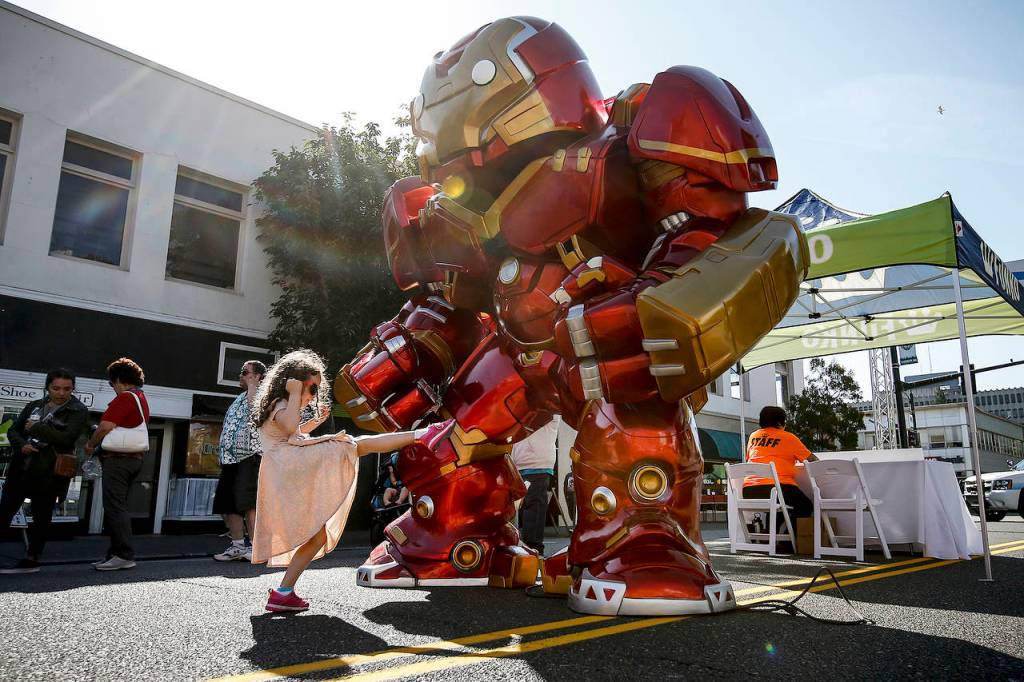 Mikaelin Hann, 6, of Everett, gives a gigantic Iron Man toy a playful kick during the grand opening of Funko in downtown Everett on Saturday. (Ian Terry / The Herald)