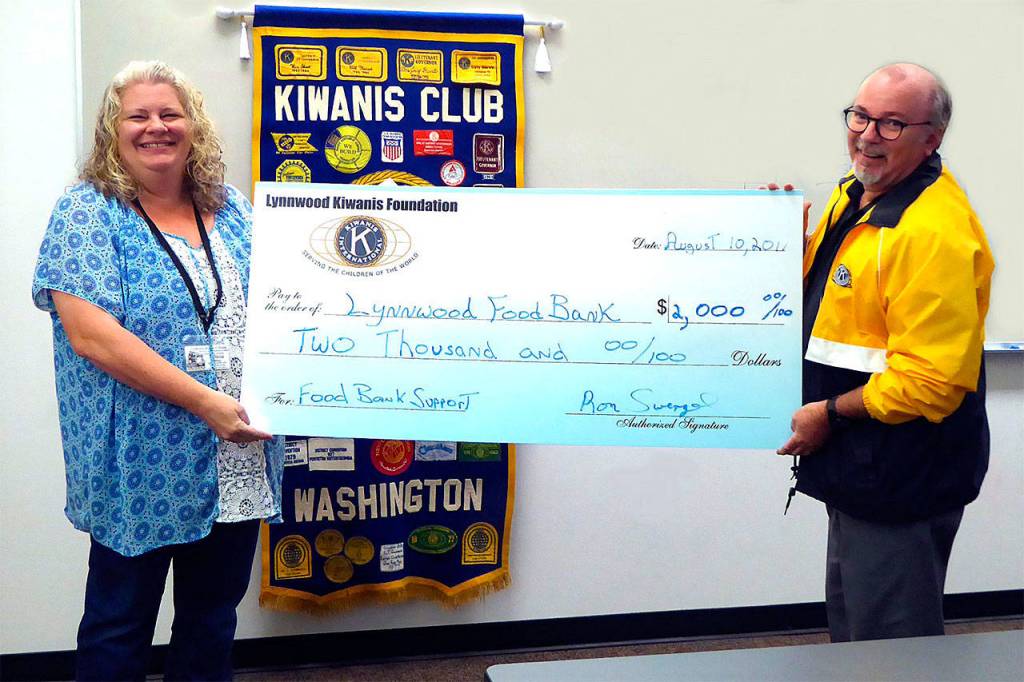 Kiwanis president Ron Swengel presents a check to Lynnwood Food Bank Director Alissa Jones on Aug. 10. (Contributed photo)