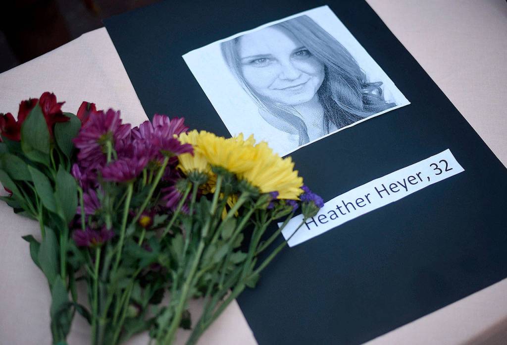 A portrait of Heather Heyer, who was killed when a vehicle drove through counter-protestors in Charlottesville, Virginia, on a table with flowers during a vigil on the campus of the University of Southern Mississippi in Hattiesburg on Monday. (Courtland Wells/The Vicksburg Post via AP)