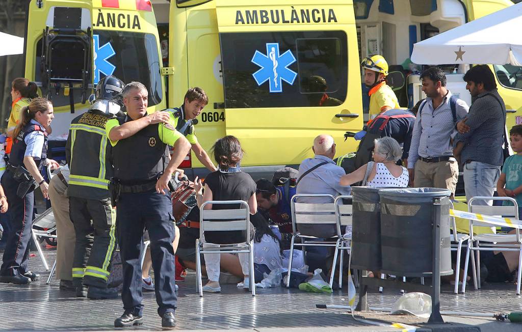 Injured people are treated in Barcelona, Spain, on Thursday after a white van jumped the sidewalk. (AP Photo/Oriol Duran)