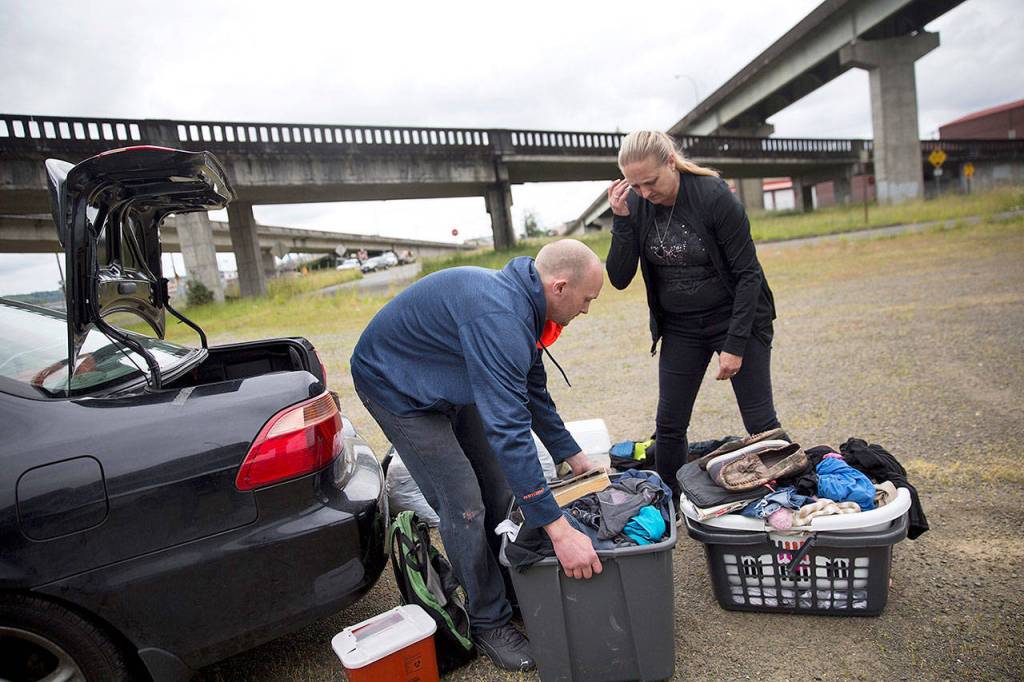 Staci Hadley (right) and boyfriend Deric Hensler rearrange their personal items out of their car, which they are living out of in Aberdeen, on June 14. (AP Photo/David Goldman)