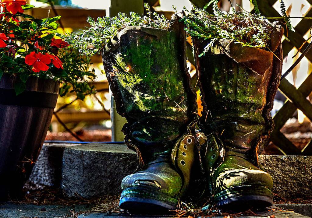 Jim Mathis retired his well-worn lineman&rsquo;s boots to the garden, where they humbly serve as a reminder of nearly four decades of exceptionally hard work. (Dan Bates / The Herald)