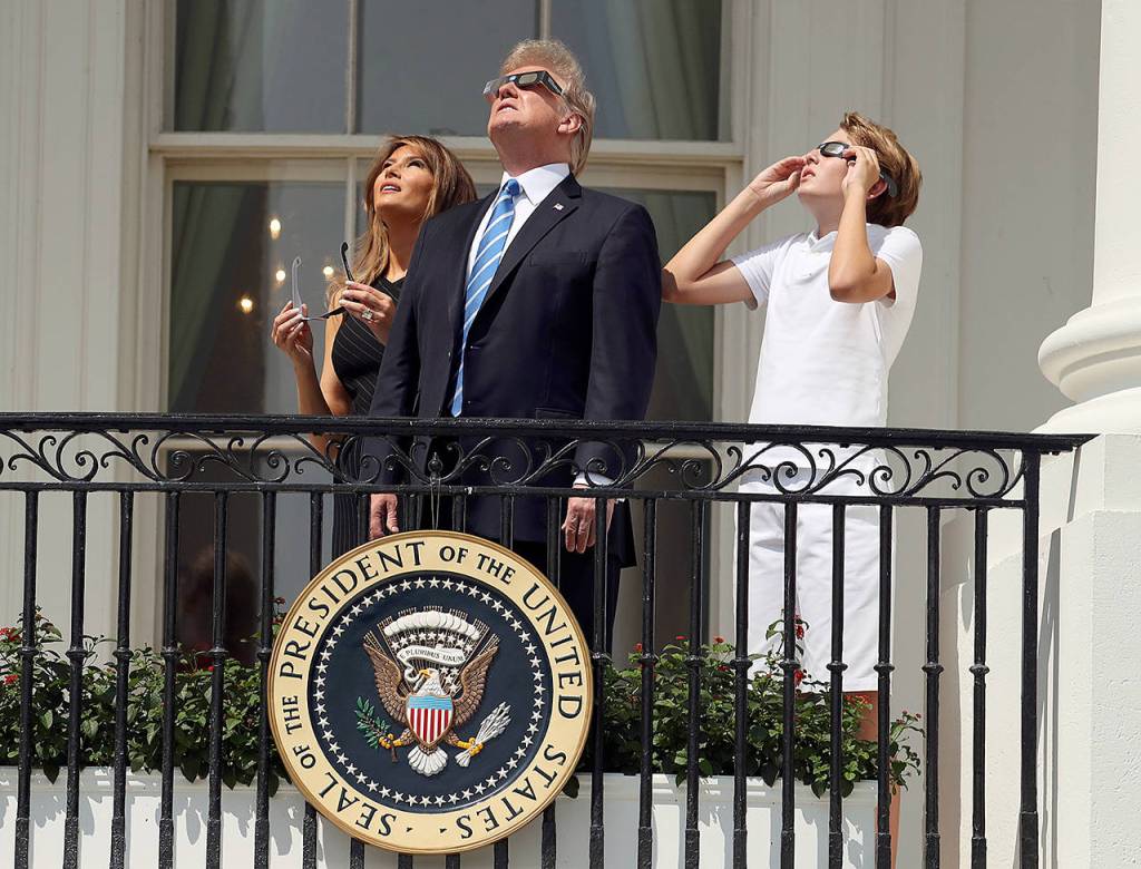 President Donald Trump, first lady Melania Trump and their son, Barron, watch the solar eclipse on Monday at the White House in Washington. (AP Andrew Harnik)