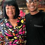 Cookie Johnson and her grandson, Deyonte Weather, share a laugh at her Everett salon. (Gale Fiege / The Herald)
