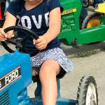Gale Fiege / The Herald                                Paige Snitily, 3, of Edmonds, tries out the pedal tractors set out by the Sky Valley Tractor Club at the fair.