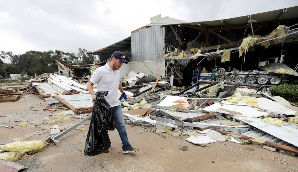 Miguel Debernardis cleans up debris in the aftermath of Hurricane Harvey on Saturday in Katy, Texas. (AP Photo/David J. Phillip)