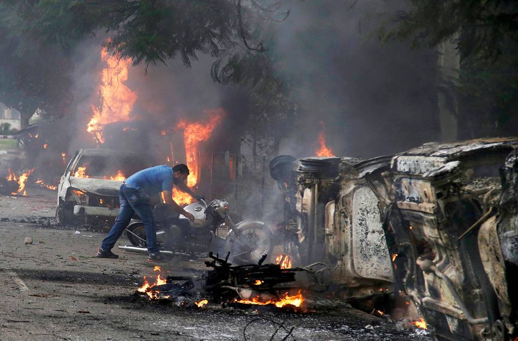 A man lifts a motorbike in a vandalized area by Dera Sacha Sauda sect members in Panchkula, India, on Friday. (AP Photo/Altaf Qadri)