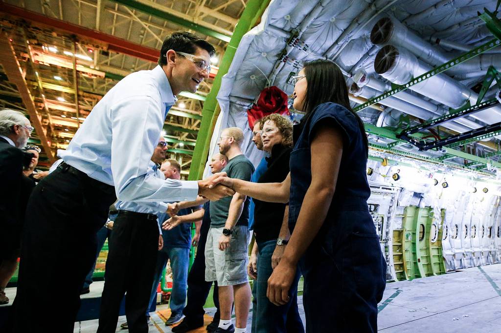 House Speaker Paul Ryan (left) greets Mau Phengmuang, a mechanic, and other Boeing employees during a tour of the Everett factory on Aug. 24. (Ian Terry / The Herald)
