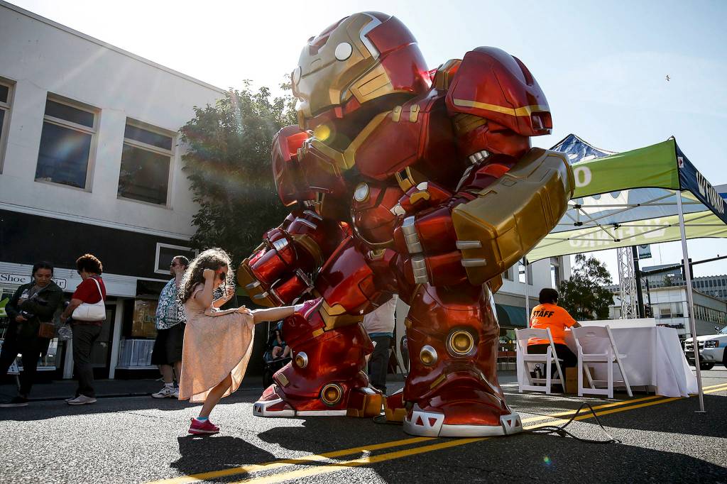 Mikaelin Hann, 6, of Everett, gives a gigantic Iron Man toy a playful kick during the grand opening of Funko in downtown Everett on Aug. 19. (Ian Terry / The Herald)