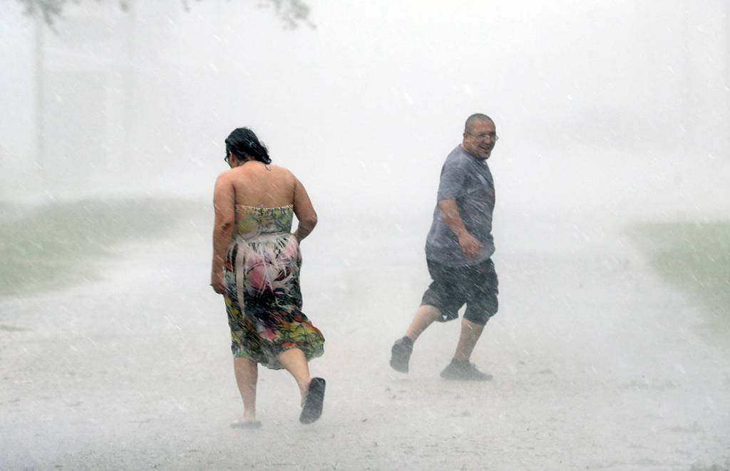 Antonio Barron (right) looks back to his girlfriend, Melissa Rocha, as they run through the street during a band of heavy rain from Hurricane Harvey on Saturday in Palacios, Texas. (AP Photo/David J. Phillip)
