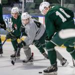 Mark Liwiski (left), Connor Dewar (center) and Conrad Mitchell all have their eyes on the puck during the Everett Silvertips&rsquo; annual Green-Grey game Sunday afternoon at Xfinity Arena in Everett. (Kevin Clark / The Herald)