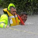 Wilford Martinez (right) is rescued from his flooded car by Harris County Sheriff&rsquo;s Department Richard Wagner along Interstate 610 in floodwaters from Tropical Storm Harvey on Sunday in Houston, Texas. (David J. Phillip / Associated Press)