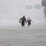 Two people walk down a flooded section of Interstate 610 in floodwaters from Tropical Storm Harvey on Sunday in Houston, Texas. (David J. Phillip / Associated Press)