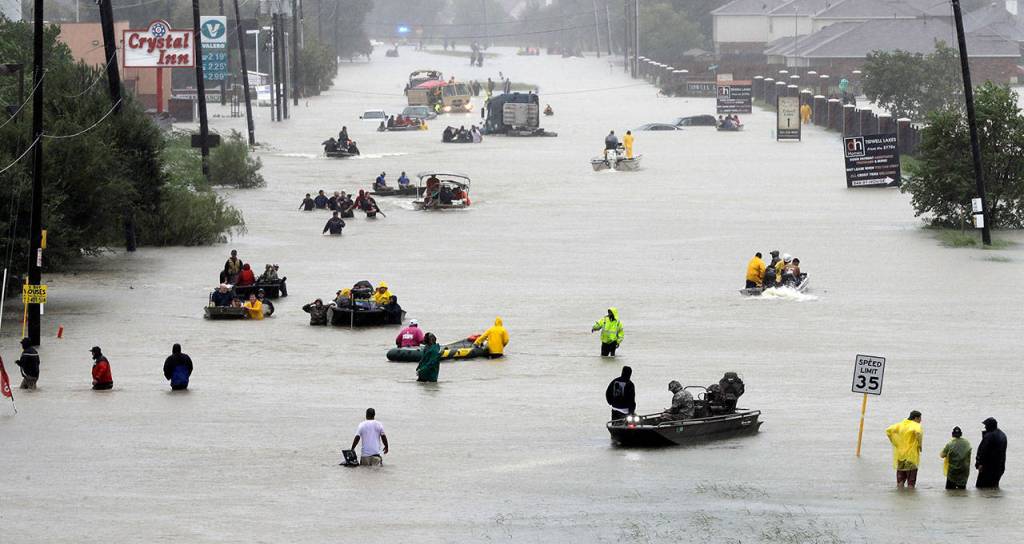 Rescue boats fill a flooded street as flood victims are evacuated as floodwaters from Tropical Storm Harvey rise Monday in Houston. (AP Photo/David J. Phillip)