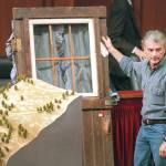 In this Sept. 6, 1995 photo, Randy Weaver holds the door of his cabin showing holes from bullets fired during the 1992 siege of his Ruby Ridge, Idaho home and a model of the landscape during testimony before the Senate Judiciary Subcommittee on Capitol Hill in Washington. (AP Photo/File, Joe Marquette, File)