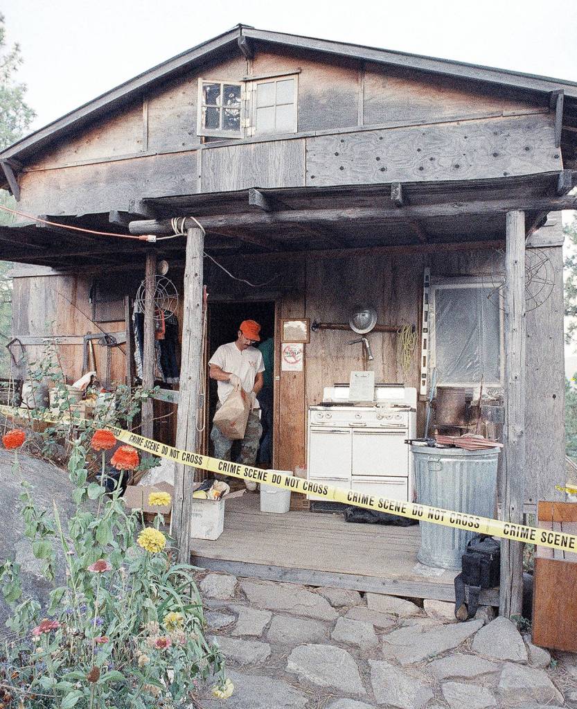 In this Aug. 31, 1992 photo, federal agents gather evidence from the home of captured fugitive Randy Weaver near Naples, Idaho. (AP Photo/Gary Stewart, File)