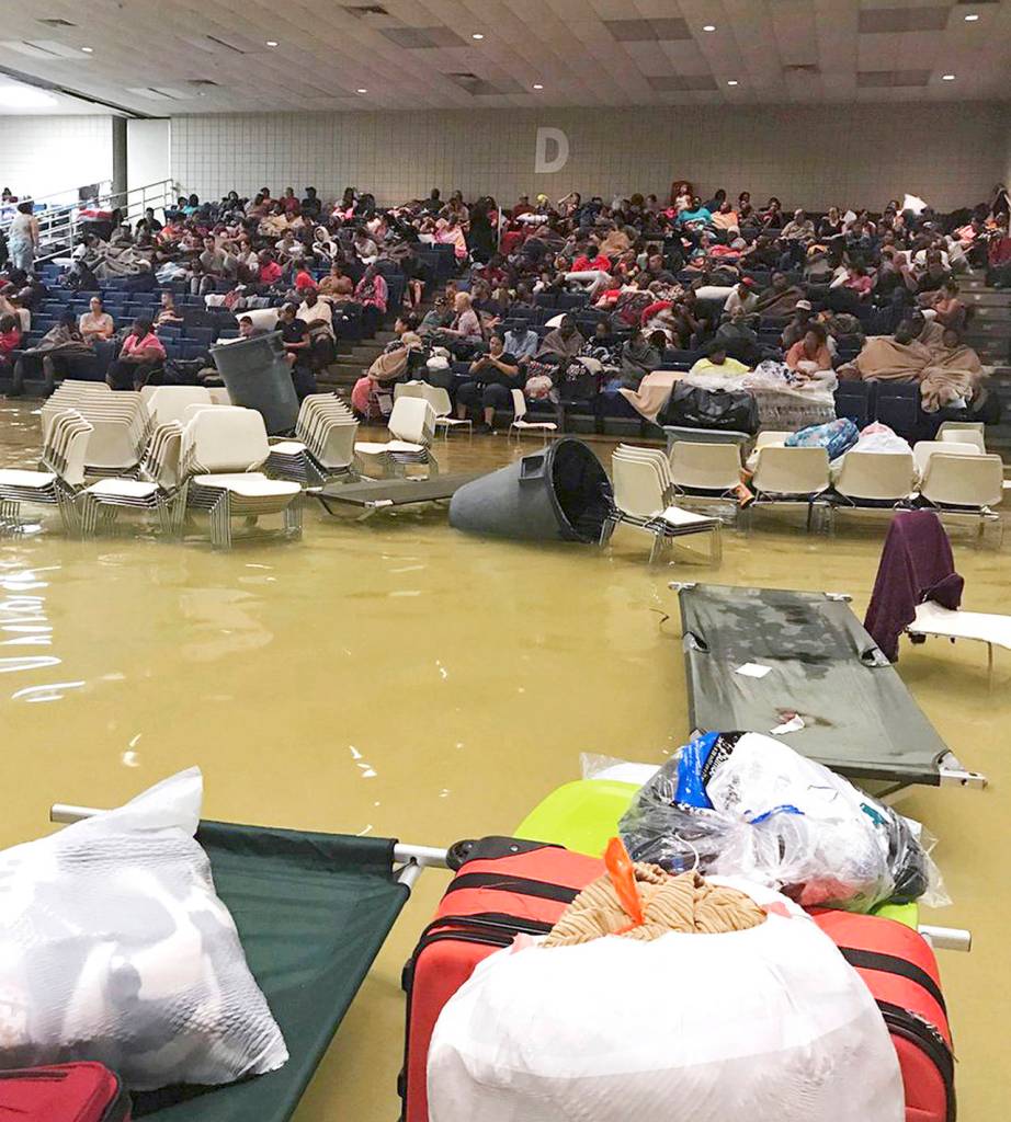 Evacuees sit in the bleachers at the Bowers Civic Center in Port Arthur, Texas, on Wednesday after floodwaters caused by Tropical Storm Harvey inundated the facility overnight. Authorities said it&rsquo;s not clear where the evacuees will go. (Beulah Johnson via AP)