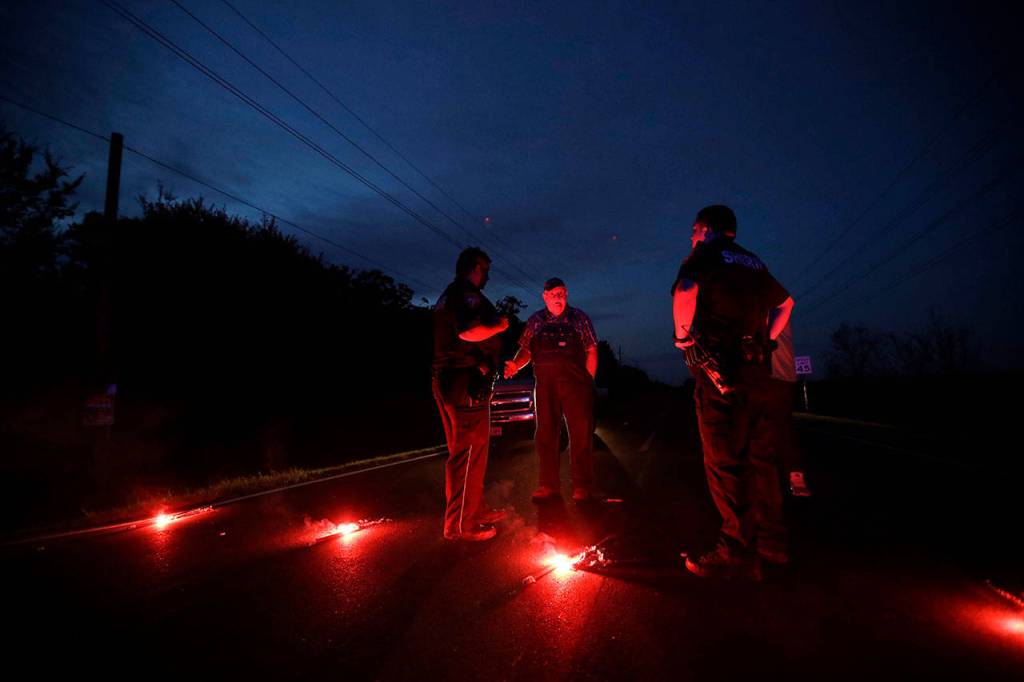 A man talks with officers at a roadblock less than three miles from the Arkema Inc. chemical plant on Thursday in Crosby, Texas. (AP Photo/Gregory Bull)
