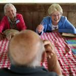 Crystal Johanson, right, gets a laugh from Liz Reed Leonard as she tells the story of getting paid to gather snakes from a neighbor&rsquo;s yard as they attend Snohomish High School&rsquo;s Class of 1942 75th reunion at Hill Park on Sept. 6 in Snohomish. (Andy Bronson / The Herald)