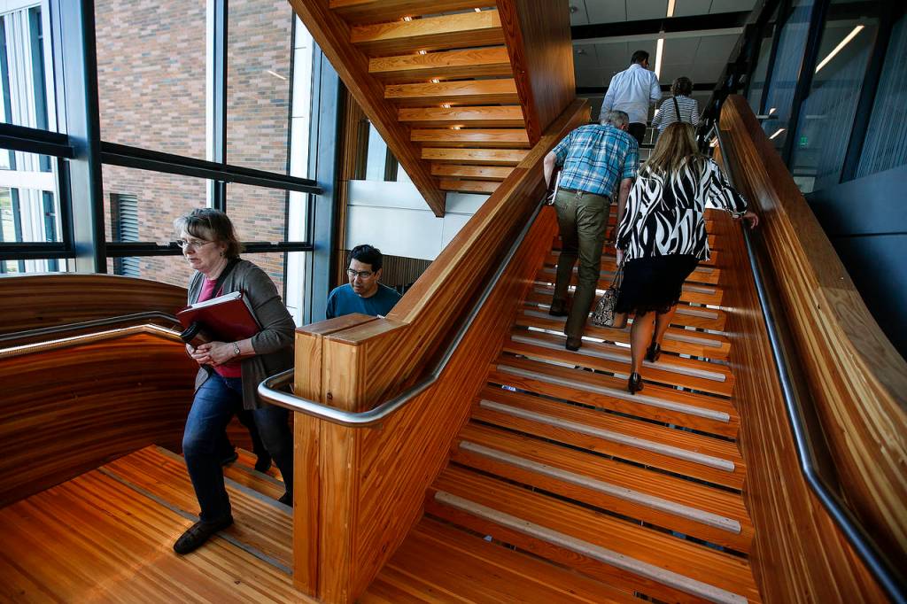Faculty who will teach WSU medical students walk up walk up central staircase of a new building on the Everett campus where the classes will be held. The tour was on May 20. (Ian Terry / The Herald)