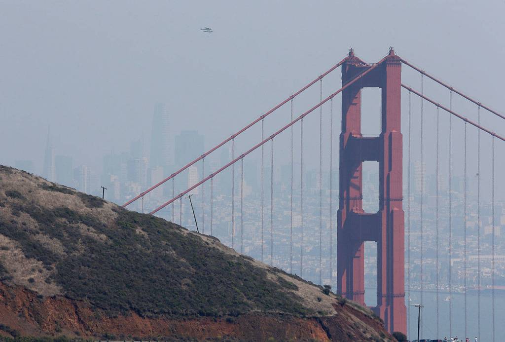 A seaplane flies over the Golden Gate Bridge Friday, Sept. 1, 2017, in this view from the Marin Headlands near Sausalito, Calif. In the background the San Francisco skyline is bare visible in near 100 degree heat. Dozens of cooling centers opened throughout California, schools let students out early and outdoor events were cancelled as temperatures soared from a heat wave expected to last through the Labor Day weekend. In normally cool and foggy San Francisco, temperatures reached 98 degrees Friday afternoon, well above the city&rsquo;s 90-degree record set for this day in 1950. (AP Photo/Eric Risberg)